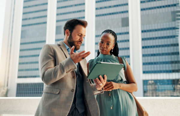 Tablet, rooftop and business people in discussion in city for planning company investment with stocks. Digital technology, strategy and manager with financial advisor for online with risk management
